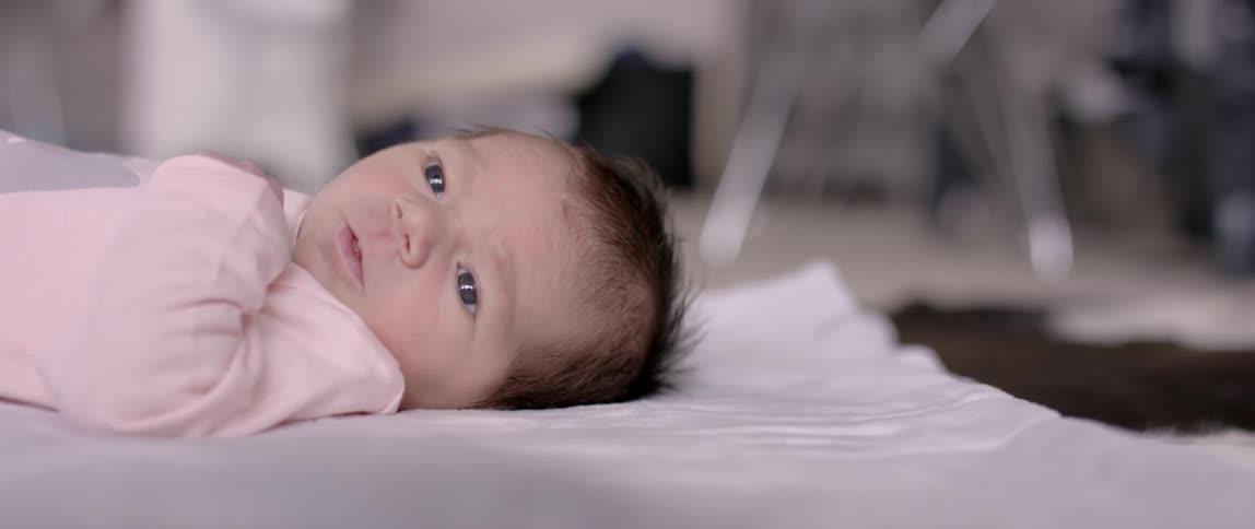 A newborn lays on a blanket