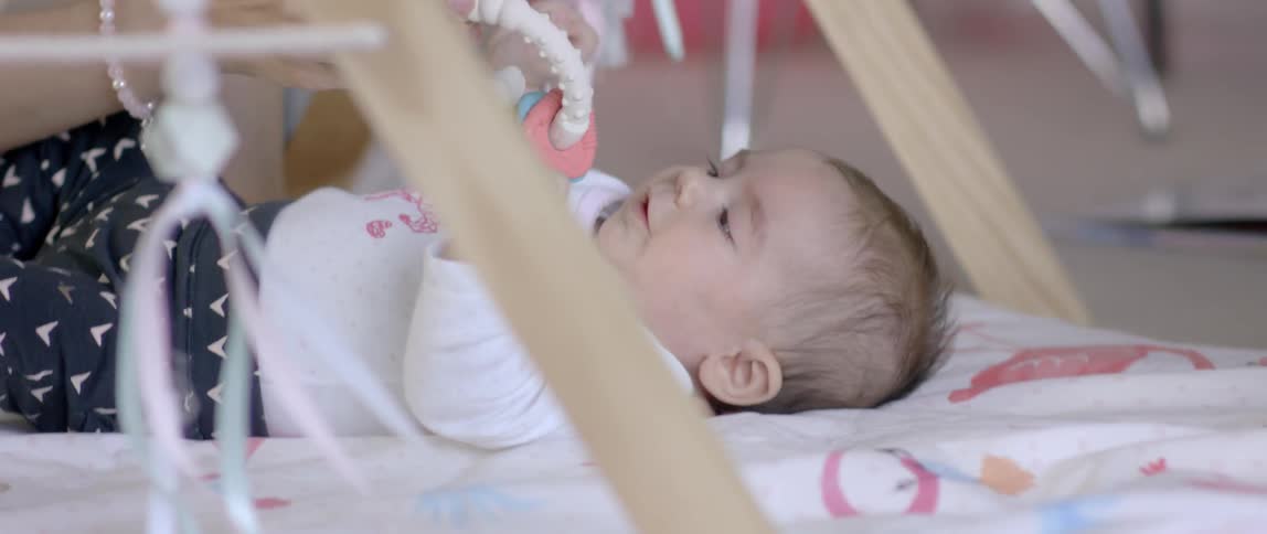 A woman gives a toy to a baby