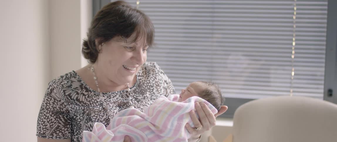 A woman holds a newborn baby
