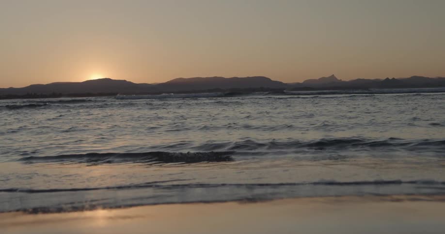 Waves crash to shore at sunset
