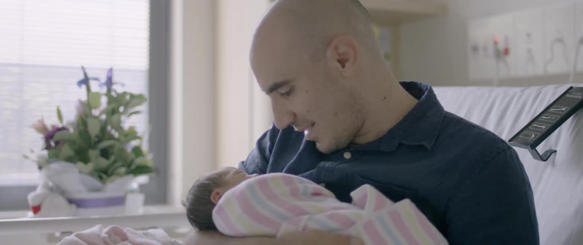 A man looks down at his baby