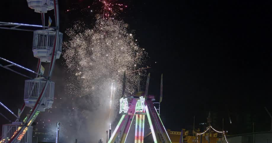 Fireworks explode at the carnival at night