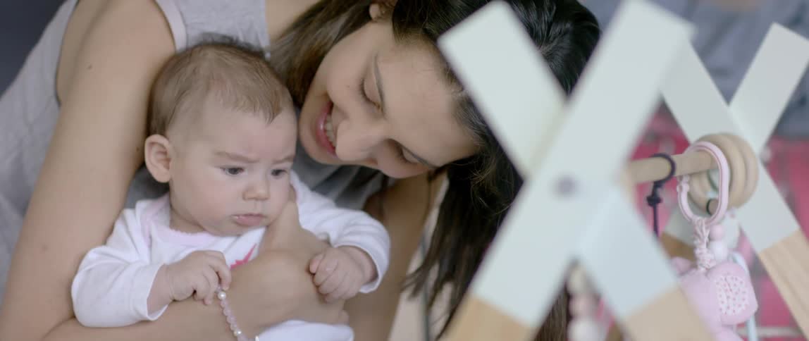 A mother is holding a baby and speaking to it
