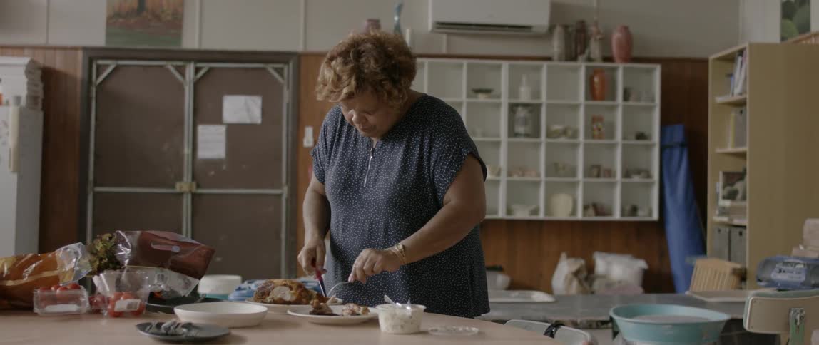 Woman cuts into a roast at a table