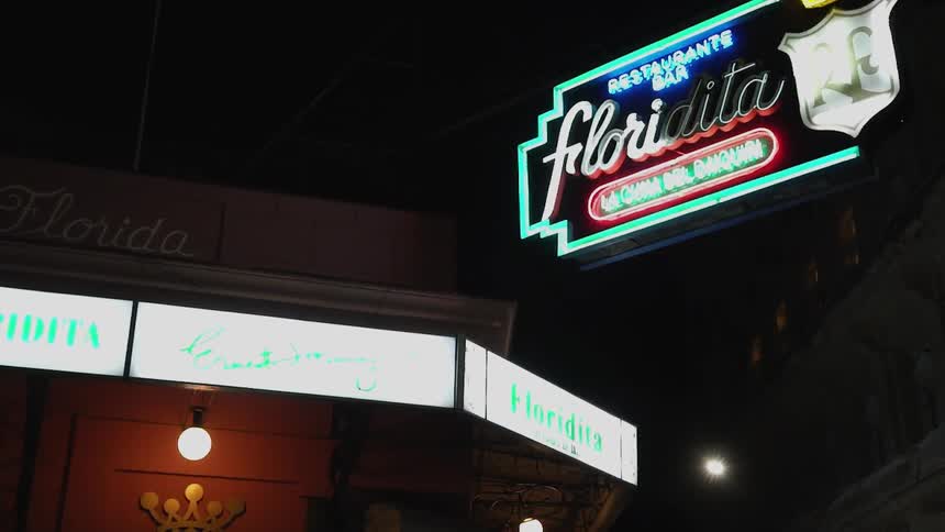A restaurant sign illuminates the dark night