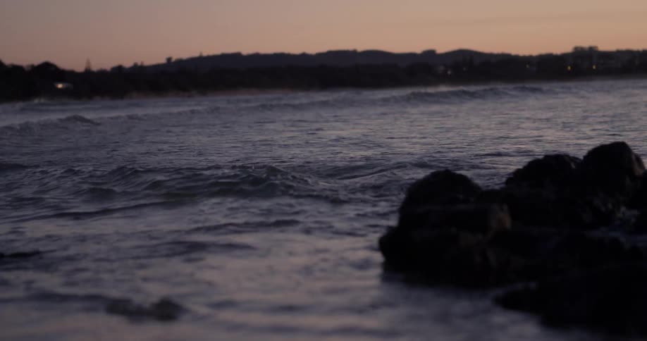Ocean waves ripple and flow at sunset