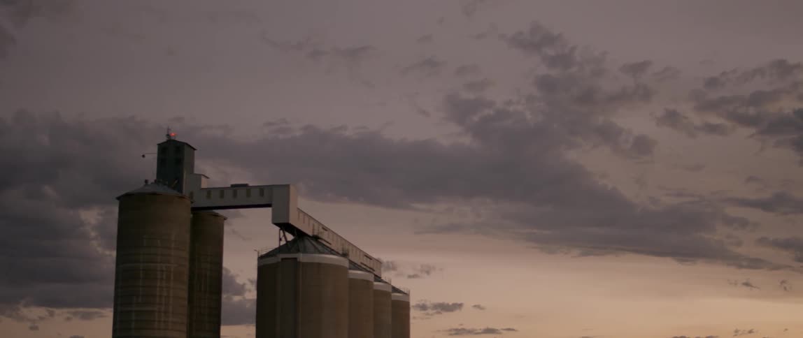 There are three silos ahead under a dawn sky