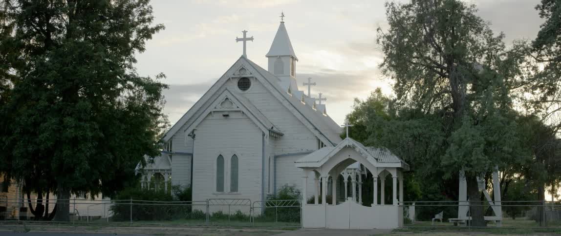 A small and rural church is shown at sunset