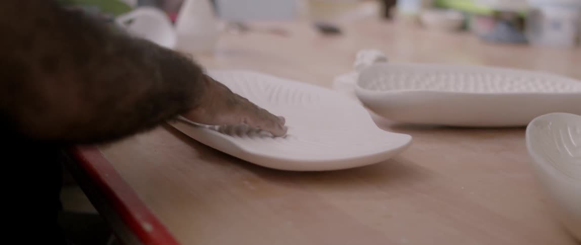 A man rubs his over the ridges in a porcelain platter