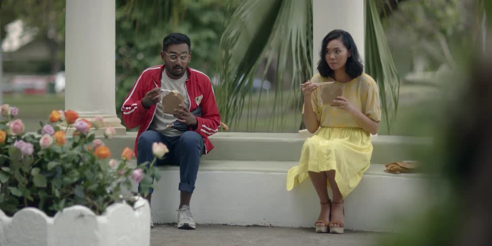 A woman hands a man a fork and the man opens an umbrella