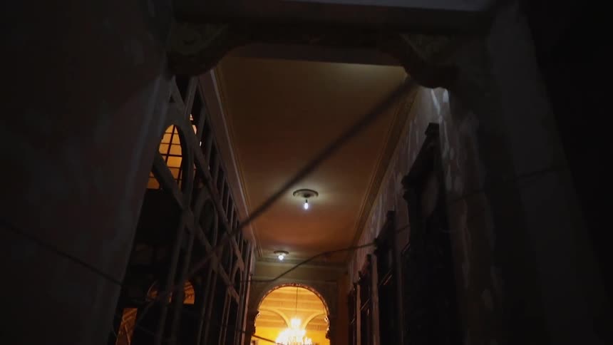 A high ceilinged hall leads to a brightly lit room
