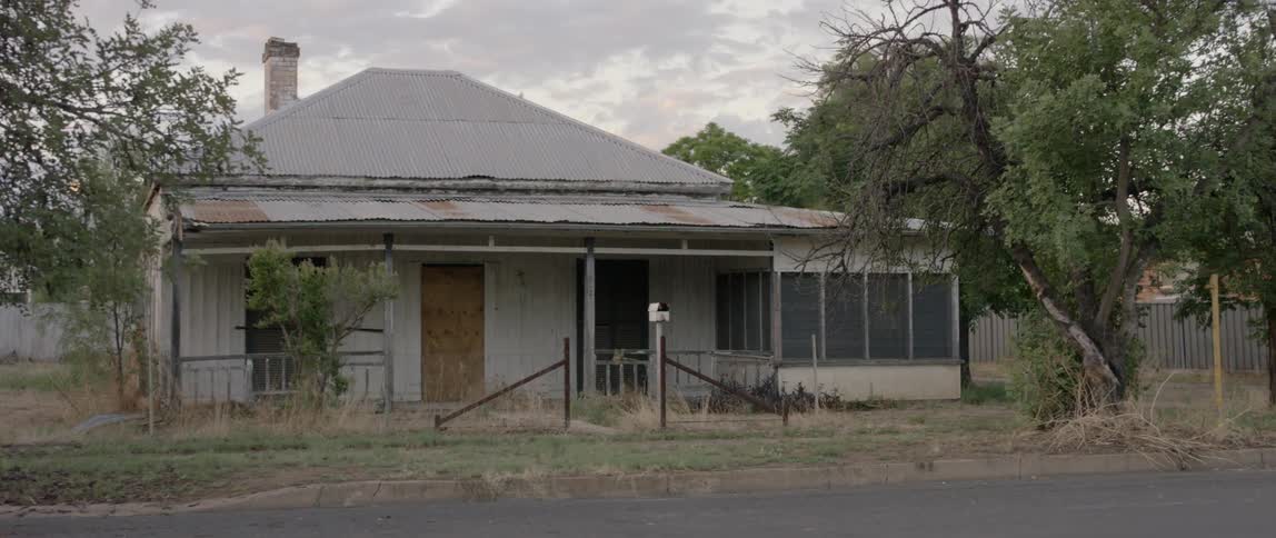 The windows and doors of a house are boarded up
