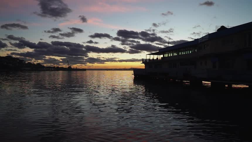 A building extends over a lake at sunset