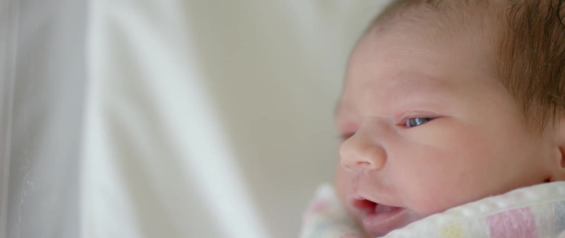 A baby is smiling in the crib