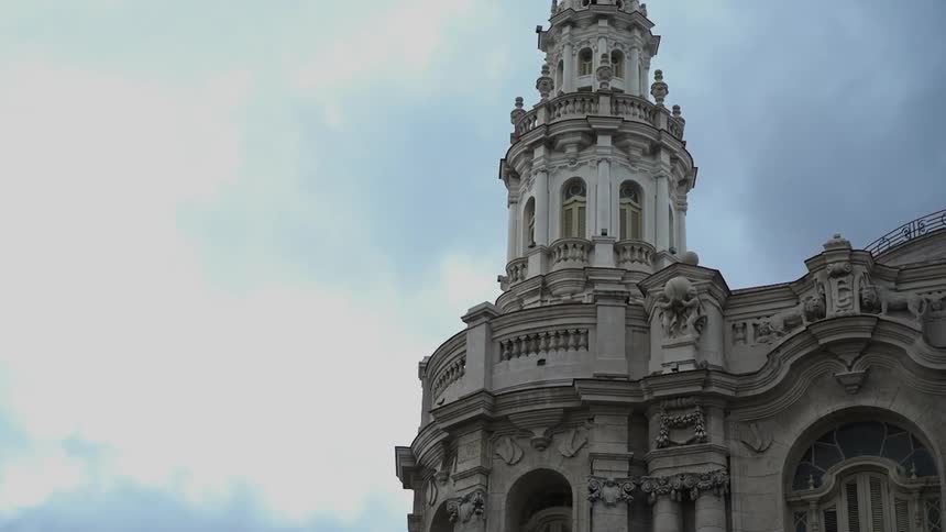 The building has a tall tower going into the clouds