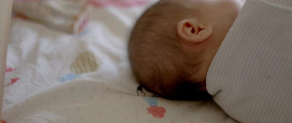 Close up of an infant's face as it rolls over