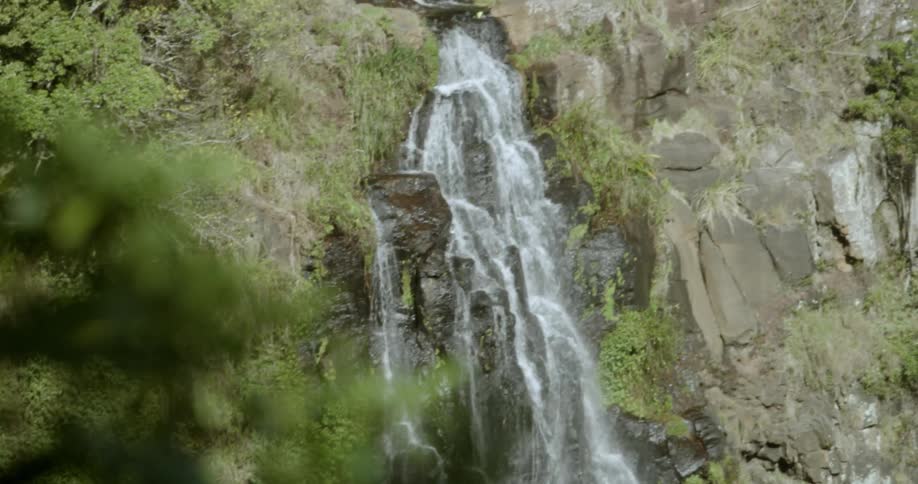 Water falls off the side of a stone mountain
