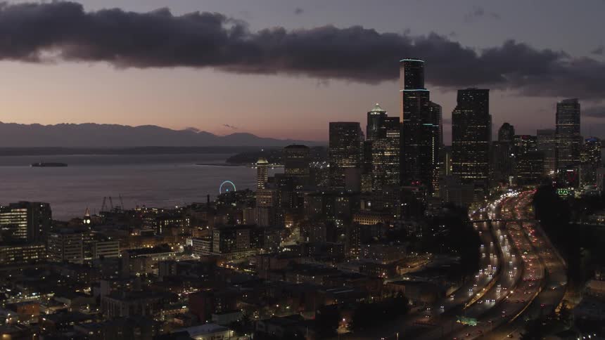 Rising beside downtown Seattle at sunset with dramatic clouds in the distance