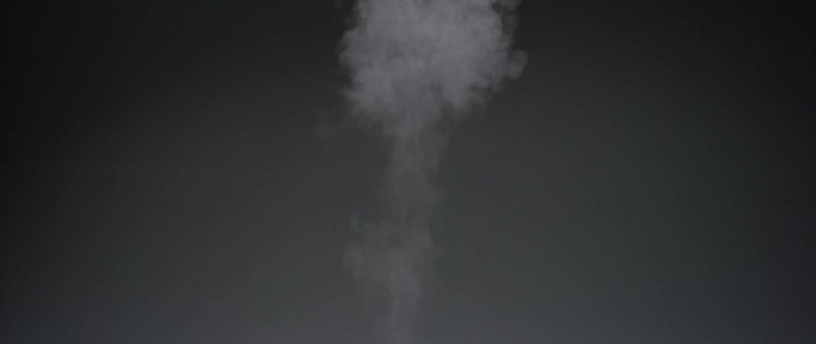 A projectile flies leaving a trail of smoke behind it