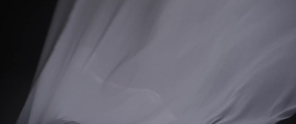 White cloth covering a person blowing in wind