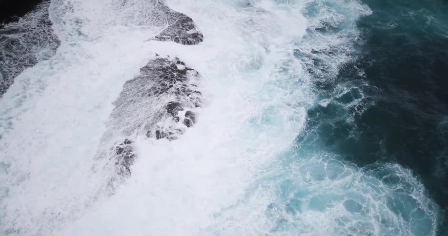 Large waves of blue water hit the shore