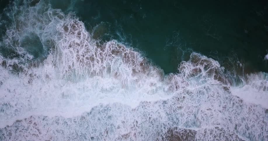 Aerial view of ocean waves crashing to shore