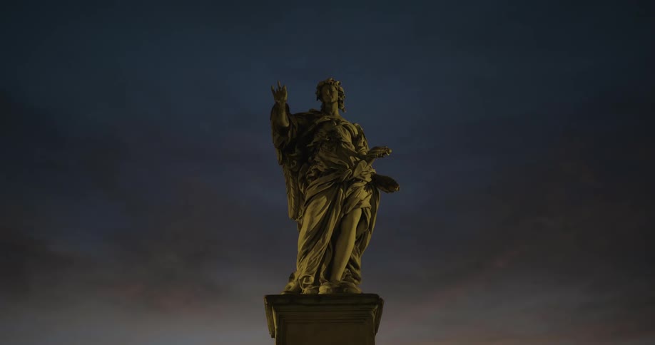 A stone statue sits perched on a pillar at dusk