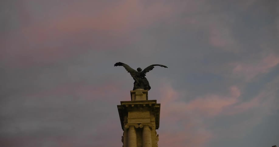 The statue lies still in the dawn sky