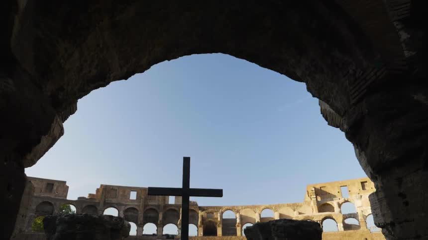 A cross stands inside old stone ruins