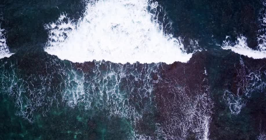 The water is clear and splashing against the shore
