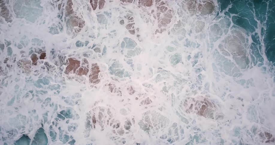 Ocean waves break and foam on the rocks