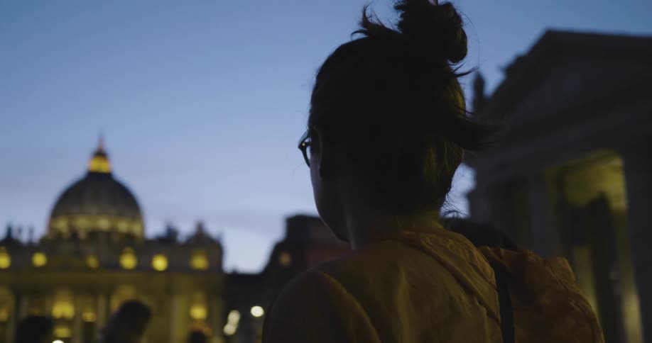 A woman is looking at a building at dawn