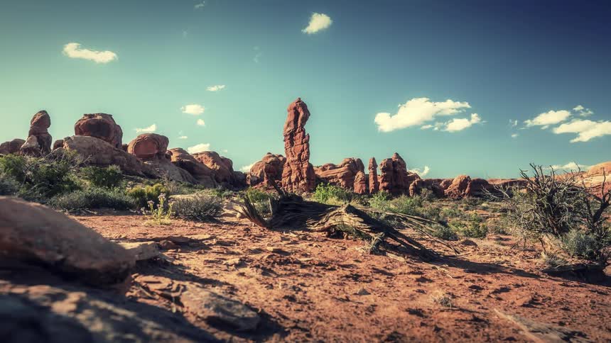 Clouds pass over rock formations in a desert