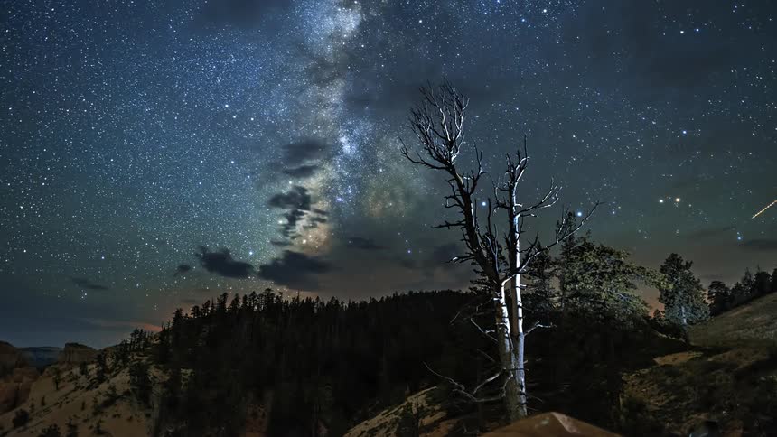 The stars move in the night sky over a high country landscape