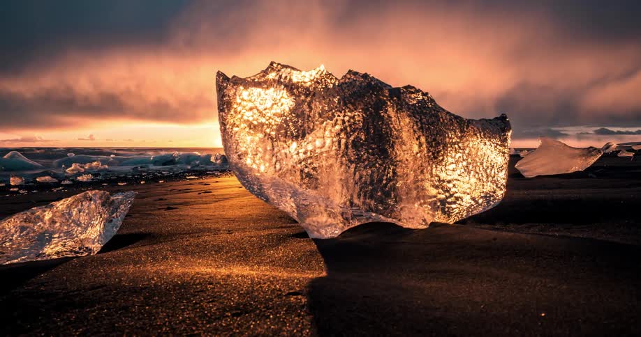 The shore is lined with large chunks of ice