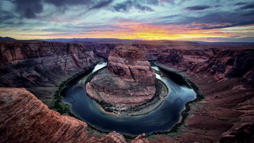 A circular stream runs around a stone in a canyon