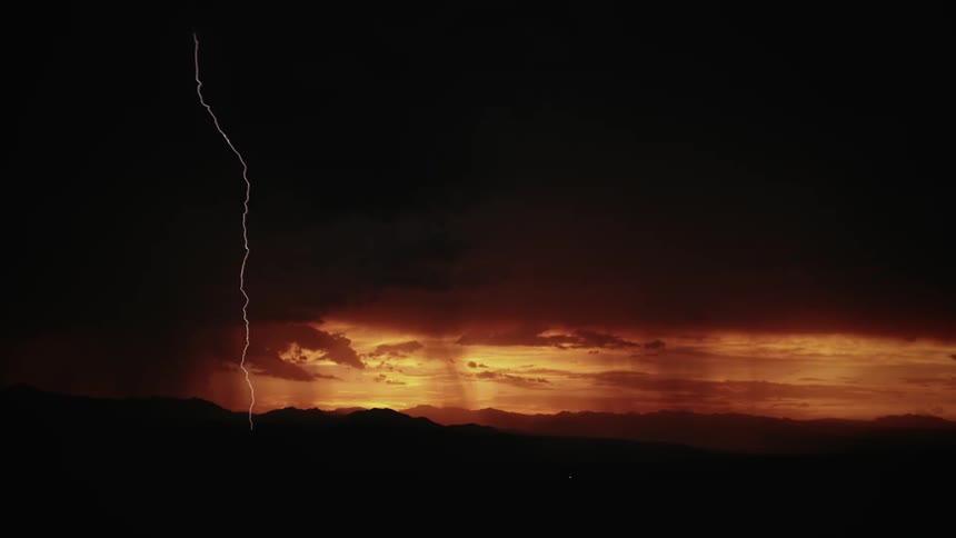 The sky is dark at dawn with lightning flashing all over