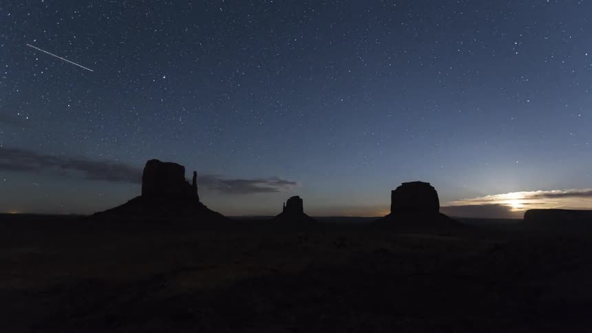 Stars overhead with the moon rising in the desert