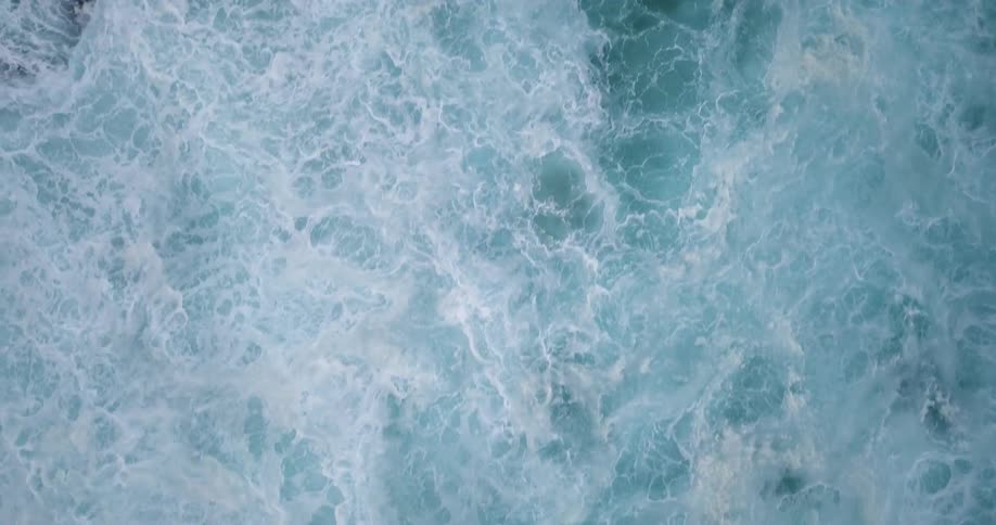 The blue waters crash giving off white waves