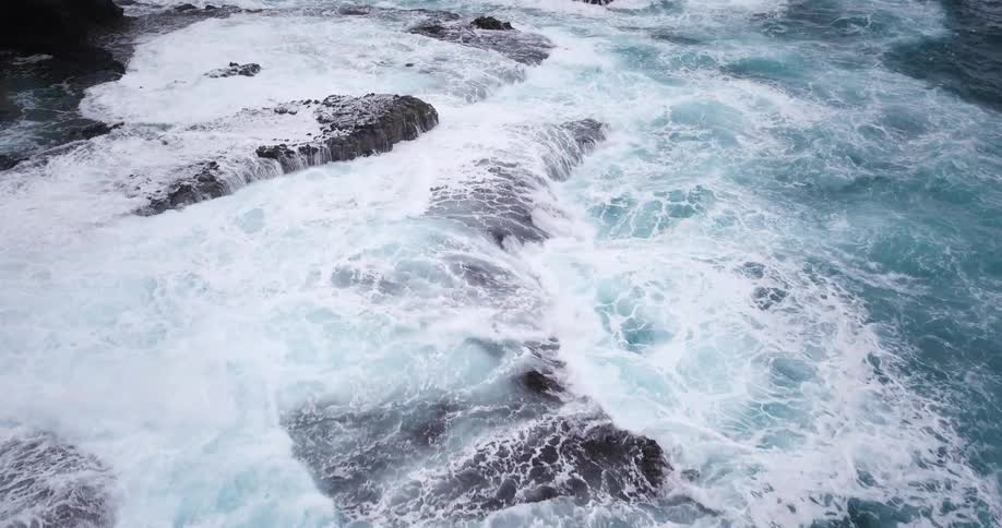 Ocean waves flow over a rocky shore