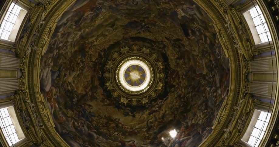 A light shines into a building's interior through the middle of a large dome