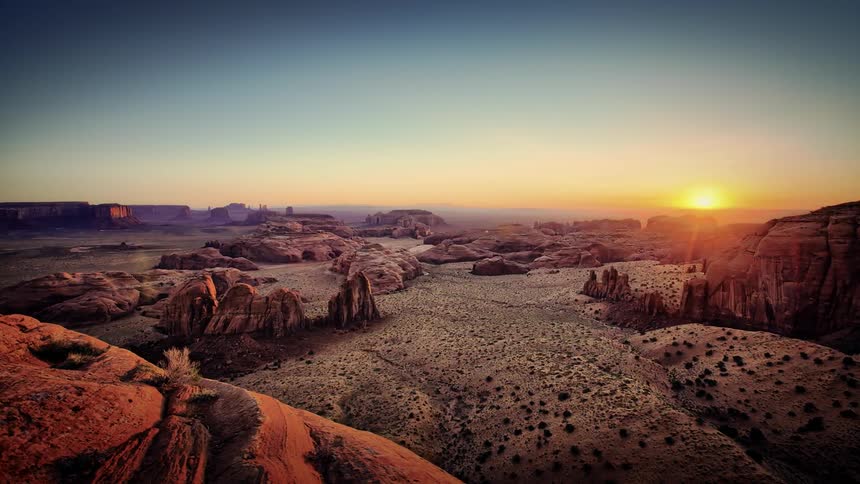The sun rises over a rocky desert landscape