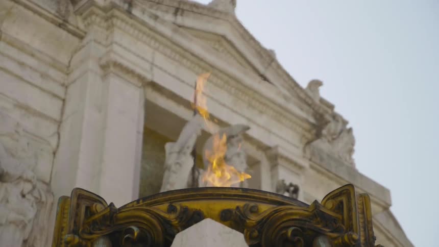 A torch flares in front of a building