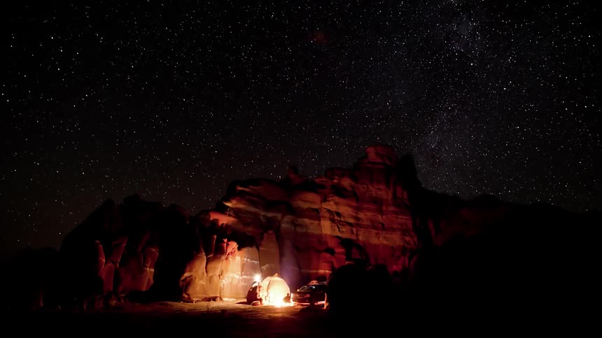 People are camping under the stars by the canyon