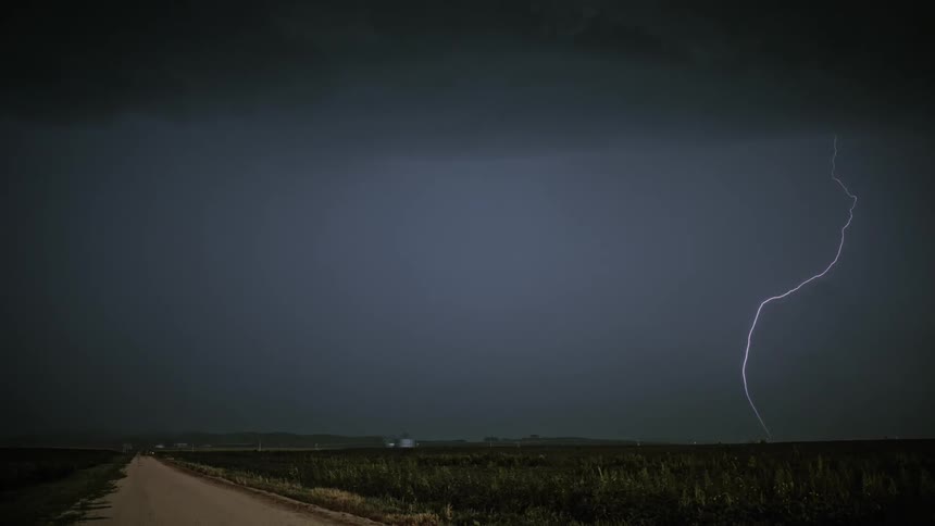Lightning strikes near the ground in an open field