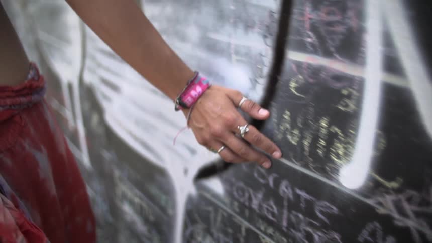 A person running their hand over a wall