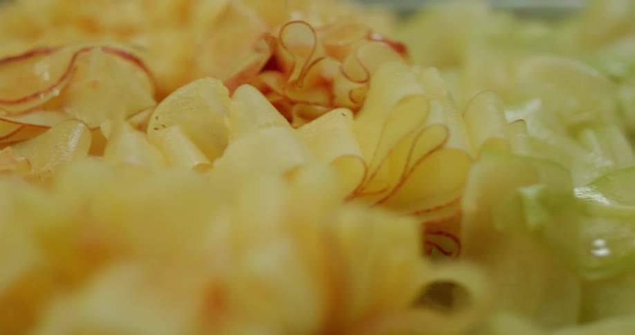 Piles of shaved vegetables sit on a table