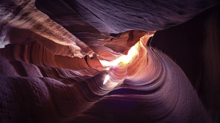 View of the inside of a sand carved cave on a sunny day