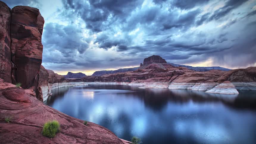 Time-lapse of clouds moving over a lake surrounded by rocky areas