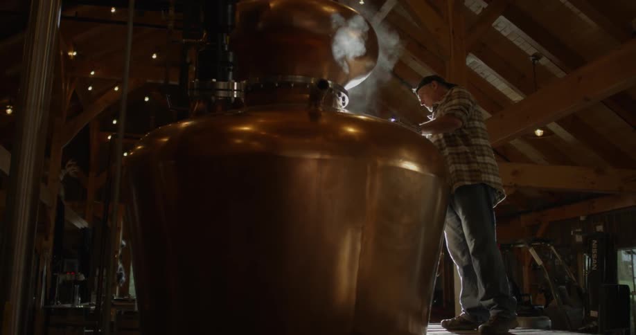 A man checks a still then closes the lid